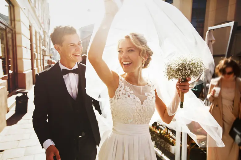 Golden wedding rings on the white rose fr...